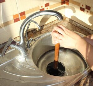 Sink drain backup being fixed with plunger