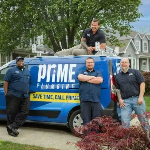 prime plumbing team members posing next to their working van