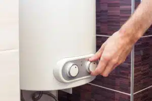 Close-up of man hands setting the temperature of water in Electric Water Heater