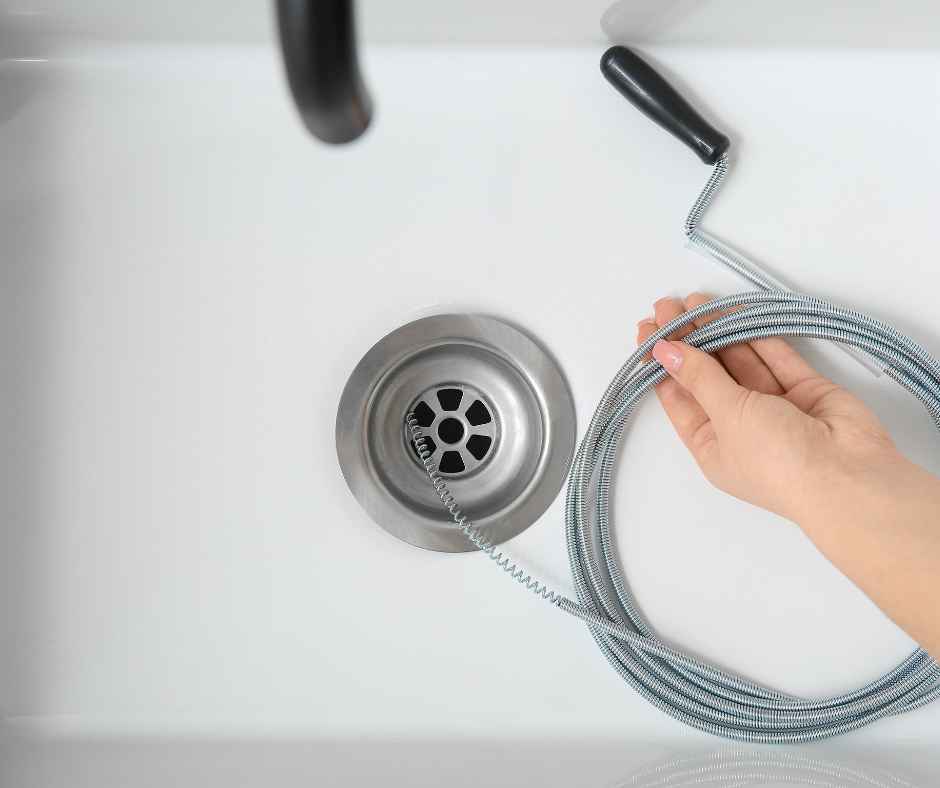 Preparing to do drain cleaning with a drain snake